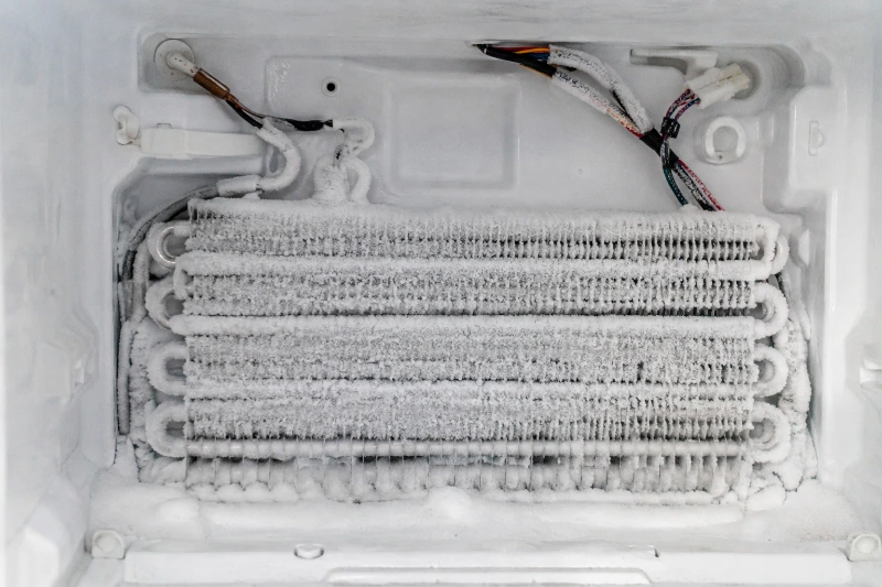 Frosted refrigerator evaporator coil showing a possible airflow and defrost problem